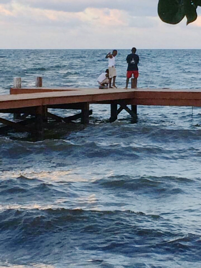 Kids crabbing off a pier in Flores, Belize